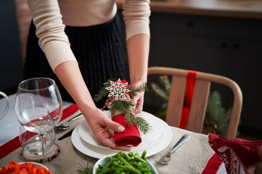 Woman preparing table for Christmas dinner